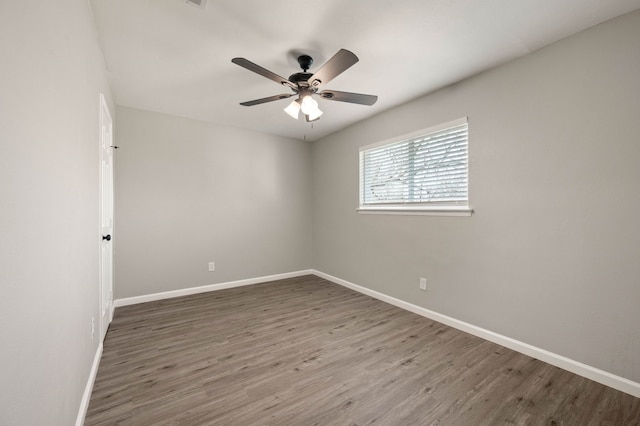 spare room featuring ceiling fan, wood finished floors, and baseboards