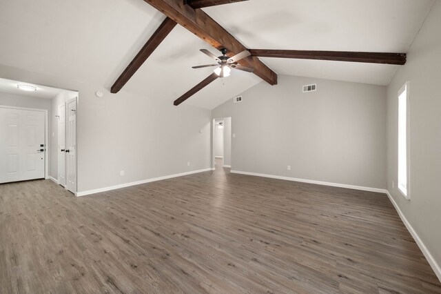 unfurnished living room featuring lofted ceiling with beams, wood finished floors, visible vents, and baseboards