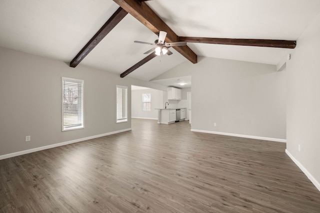 unfurnished living room featuring lofted ceiling with beams, ceiling fan, baseboards, and wood finished floors