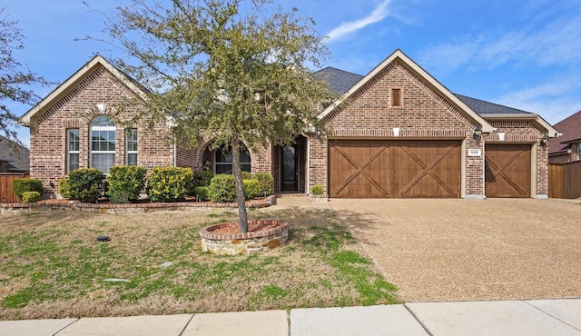 view of front facade with a garage, driveway, and brick siding