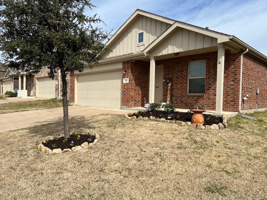 view of front facade featuring driveway, brick siding, and board and batten siding