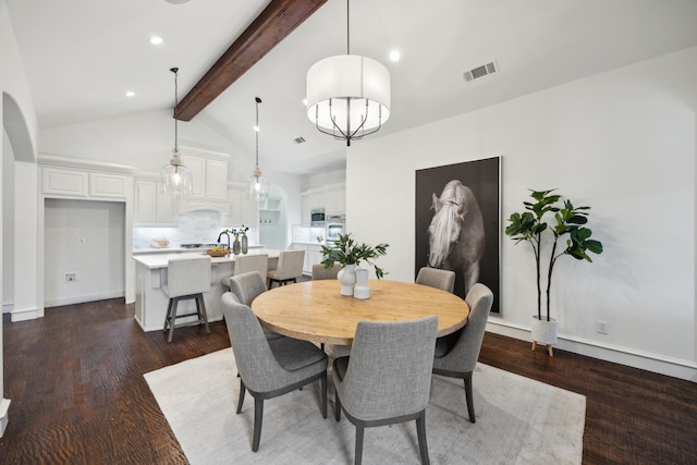 dining room featuring vaulted ceiling with beams, wood finished floors, visible vents, and baseboards