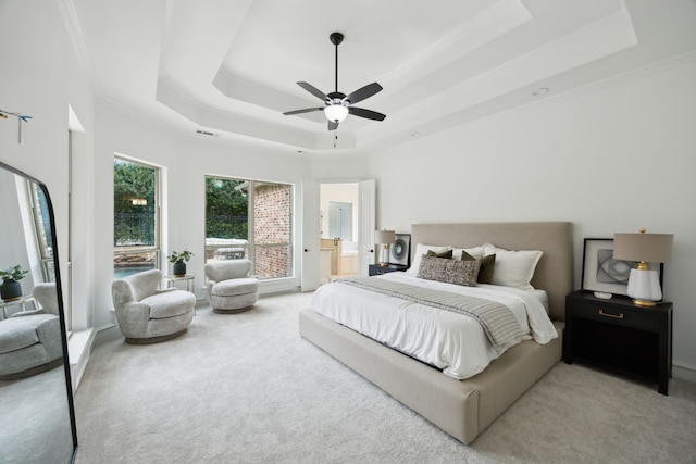 carpeted bedroom with ceiling fan, a raised ceiling, visible vents, and crown molding