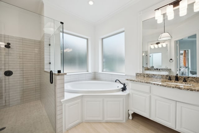 ensuite bathroom featuring a garden tub, crown molding, a shower stall, vanity, and ensuite bath