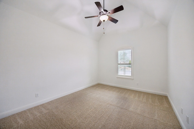 spare room featuring a ceiling fan, light colored carpet, vaulted ceiling, and baseboards