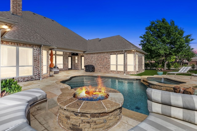 view of pool with a pool with connected hot tub, a patio, and a fire pit