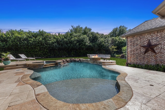 view of pool with a patio area, a pool with connected hot tub, fence, and a lawn