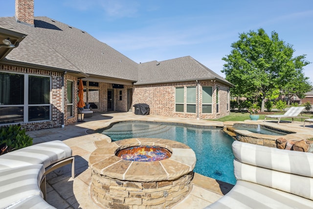 view of swimming pool featuring a fenced in pool, a patio area, a fire pit, and an in ground hot tub