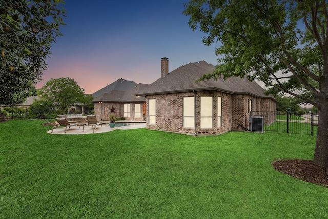 back of house featuring brick siding, a patio, a chimney, central AC unit, and fence