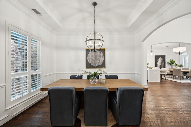 dining room featuring arched walkways, visible vents, a tray ceiling, dark wood finished floors, and crown molding