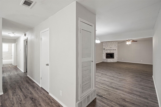 corridor with baseboards, visible vents, and dark wood-style flooring