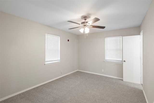 spare room featuring a ceiling fan, carpet, and baseboards