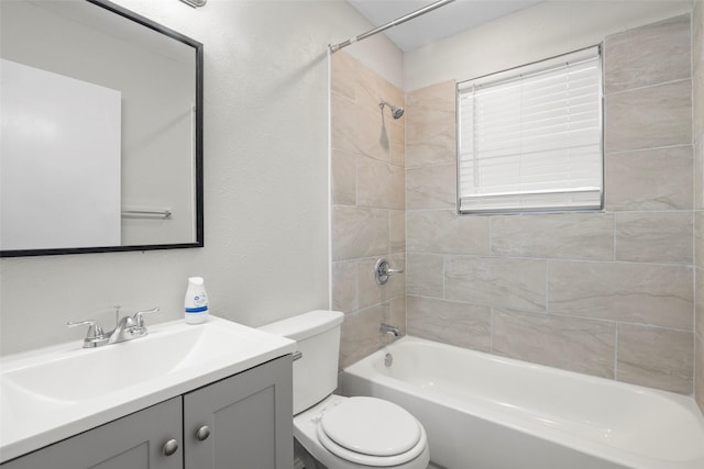 full bathroom with a textured wall, tub / shower combination, vanity, and toilet