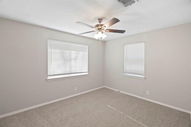 unfurnished room featuring baseboards, carpet flooring, visible vents, and a ceiling fan