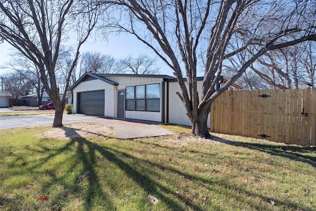 garage featuring driveway and fence