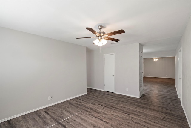 empty room with dark wood-style floors, ceiling fan, visible vents, and baseboards