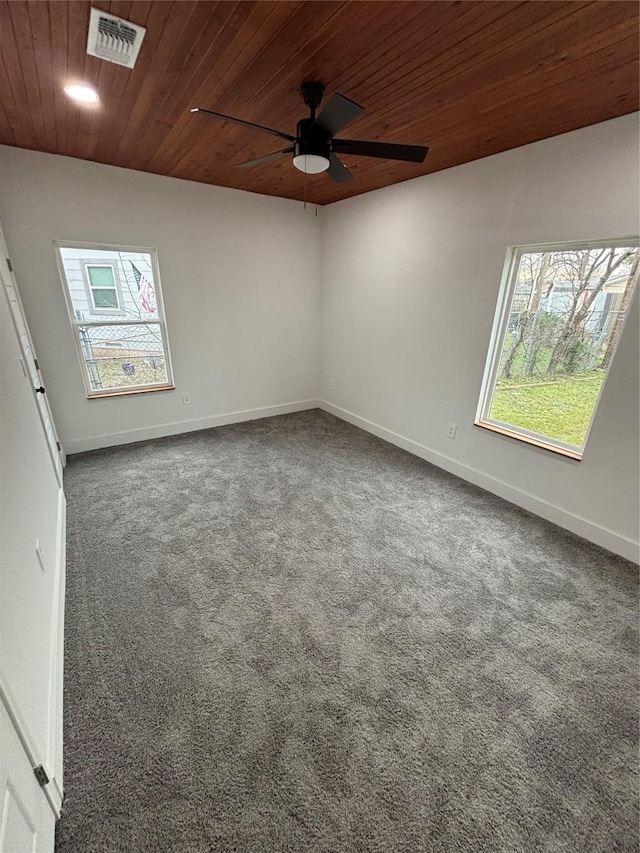 carpeted empty room with wood ceiling, plenty of natural light, visible vents, and baseboards