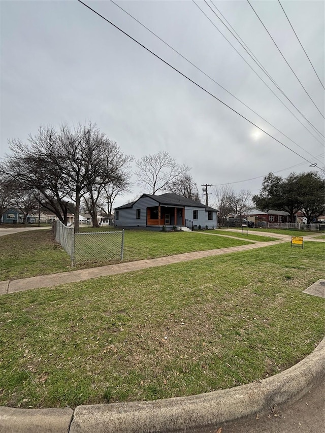 bungalow-style house with fence and a front lawn