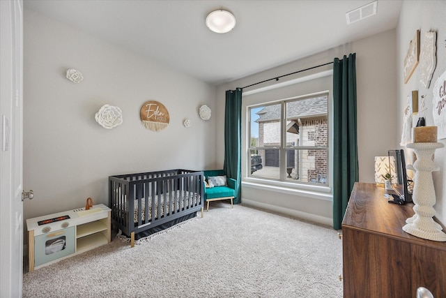 bedroom featuring a crib, carpet, visible vents, and baseboards