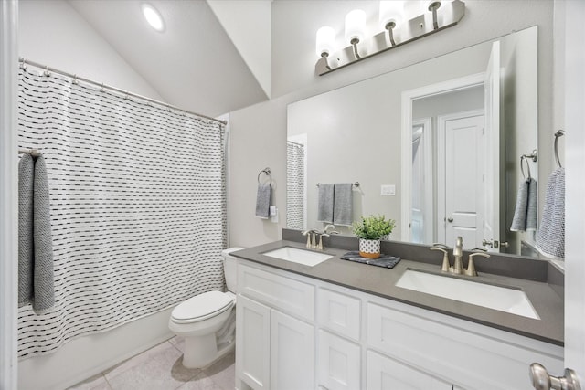 bathroom featuring toilet, double vanity, a sink, and tile patterned floors