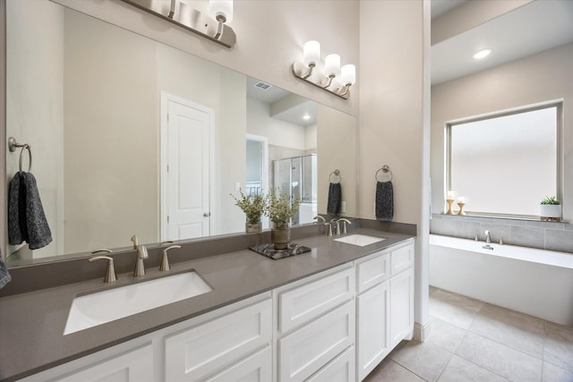 full bathroom with double vanity, a stall shower, a sink, and visible vents