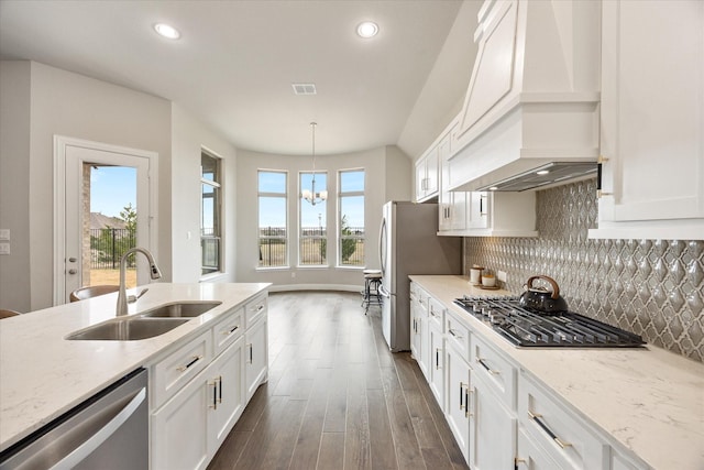 kitchen with a sink, white cabinetry, appliances with stainless steel finishes, backsplash, and custom exhaust hood