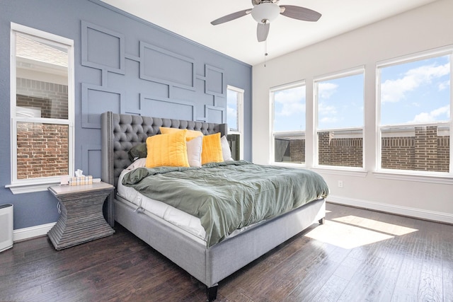 bedroom with ceiling fan, dark wood-type flooring, and baseboards