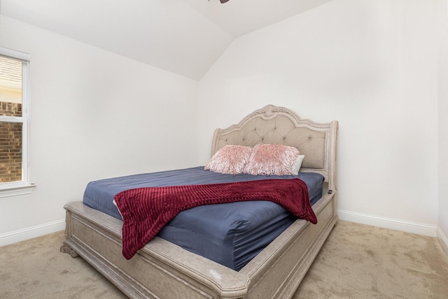 carpeted bedroom featuring lofted ceiling and baseboards