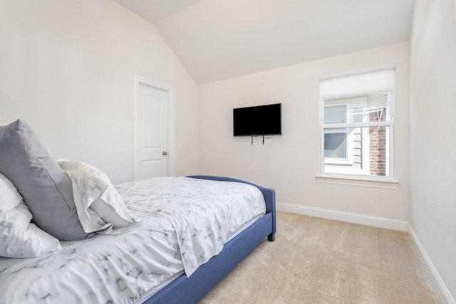 bedroom featuring baseboards, vaulted ceiling, and light colored carpet