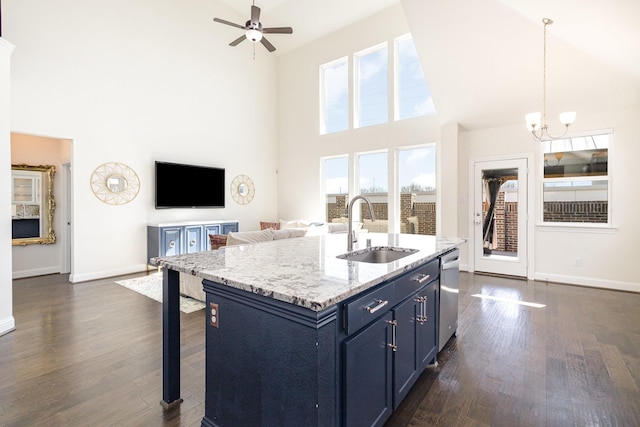 kitchen with blue cabinets, dark wood finished floors, a sink, and stainless steel dishwasher