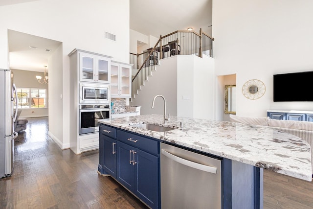 kitchen with visible vents, white cabinets, appliances with stainless steel finishes, blue cabinetry, and a sink