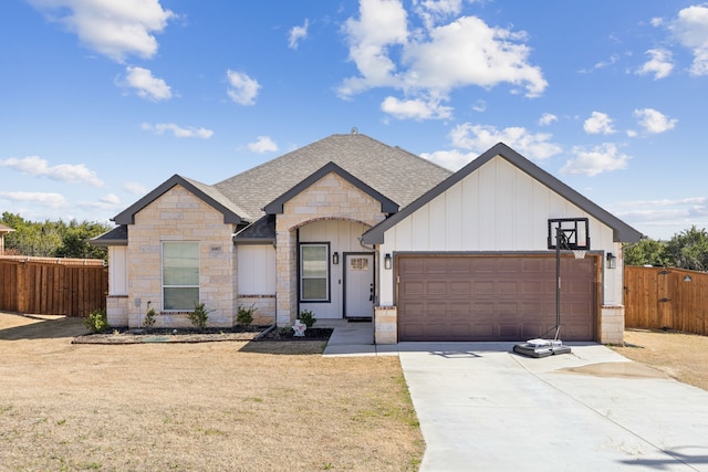 view of front of home with a shingled roof, board and batten siding, fence, a garage, and driveway