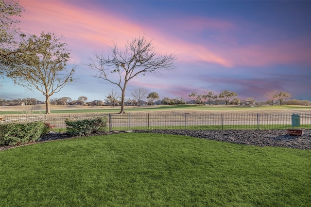 yard at dusk featuring fence