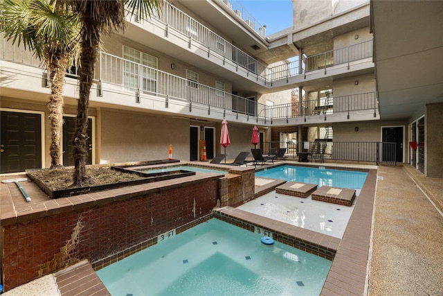 community pool with a community hot tub and a patio