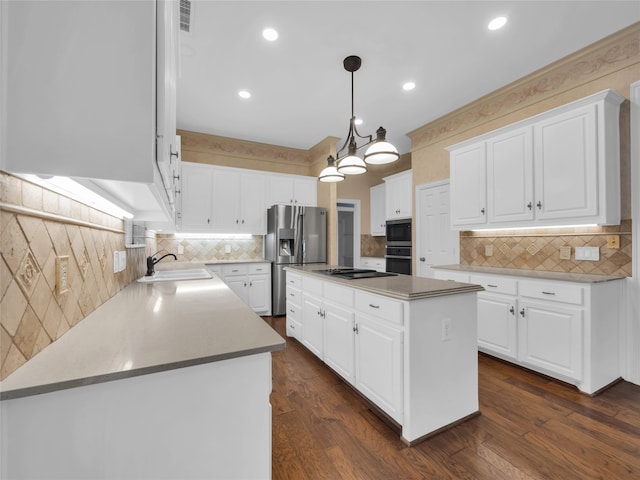 kitchen with a kitchen island, a sink, white cabinetry, appliances with stainless steel finishes, and dark wood finished floors