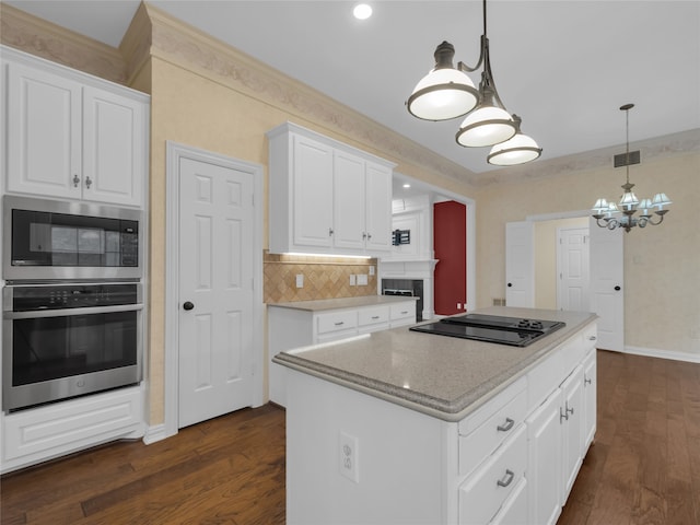 kitchen with a kitchen island, appliances with stainless steel finishes, white cabinets, and dark wood-style flooring