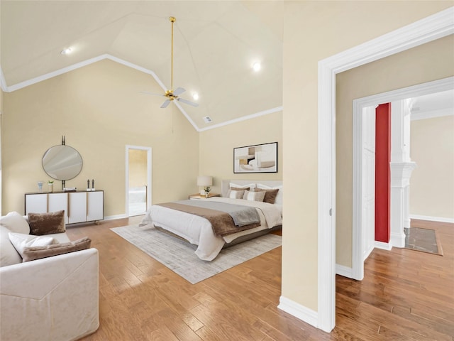 bedroom with light wood-style flooring, ornamental molding, ceiling fan, high vaulted ceiling, and baseboards