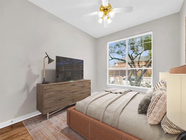 bedroom with ceiling fan, baseboards, and wood finished floors