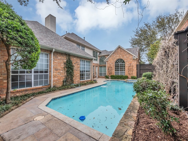 view of pool featuring a patio area, a pool with connected hot tub, and fence