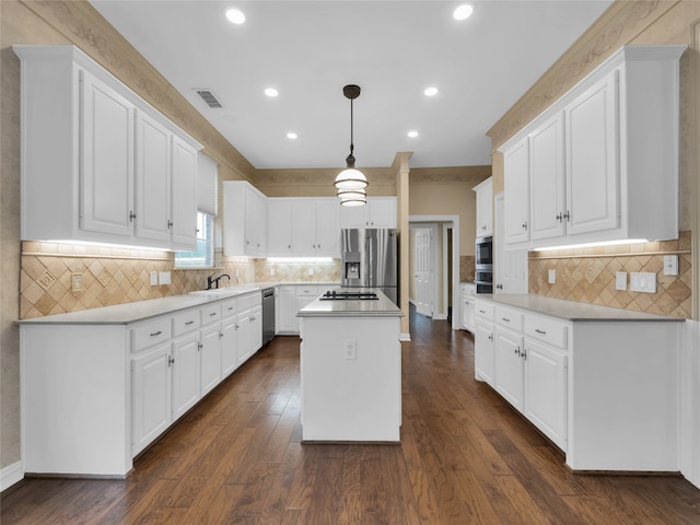 kitchen with stainless steel appliances, a center island, visible vents, and white cabinetry