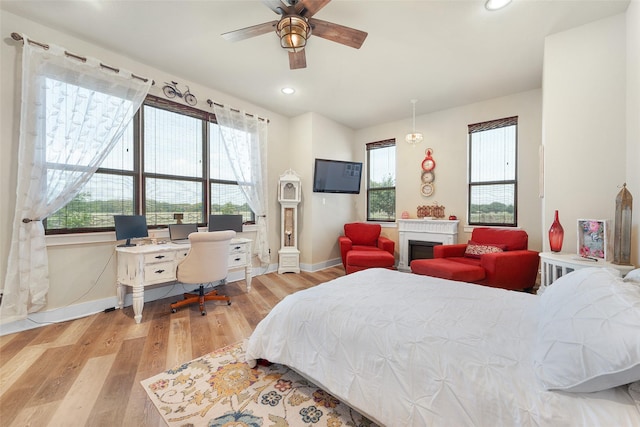 bedroom featuring recessed lighting, multiple windows, baseboards, and wood finished floors