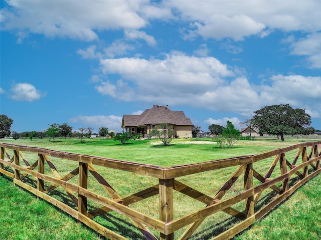 view of gate featuring a yard, fence, and a rural view