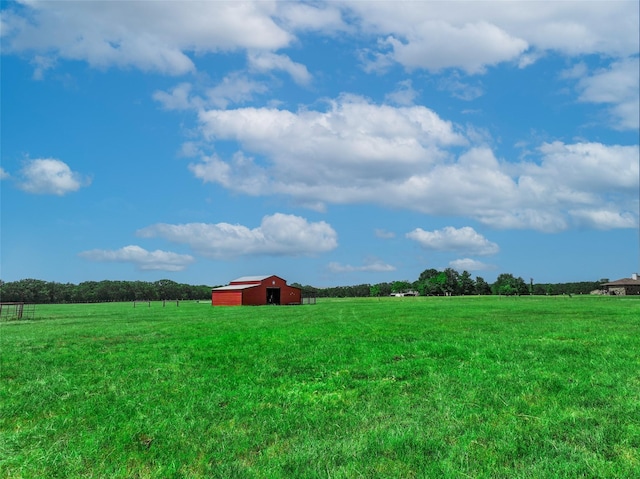 view of yard featuring an outbuilding, a pole building, and a rural view