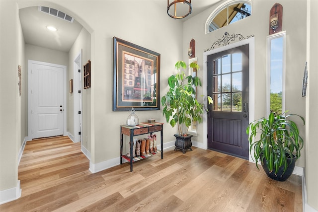 foyer entrance with visible vents, baseboards, and wood finished floors