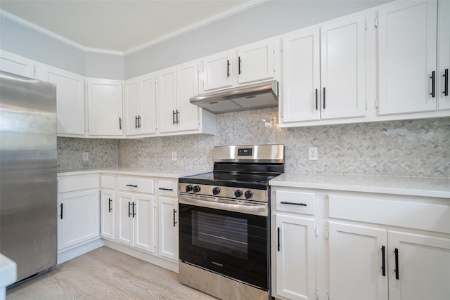 kitchen with under cabinet range hood, appliances with stainless steel finishes, light countertops, and decorative backsplash