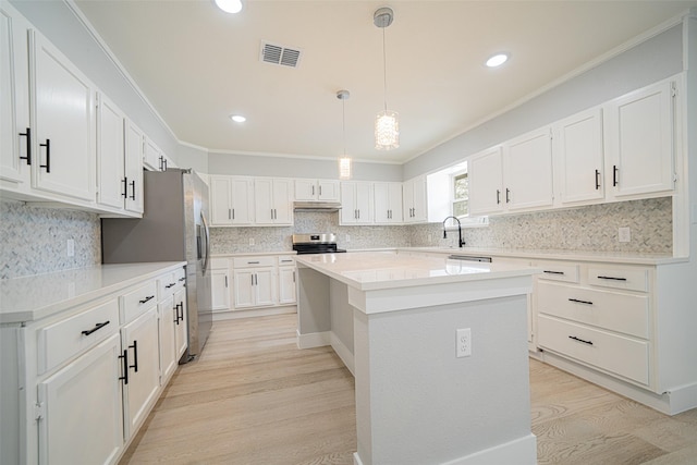 kitchen featuring a center island, light wood finished floors, visible vents, appliances with stainless steel finishes, and under cabinet range hood