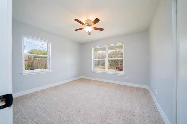 spare room with a ceiling fan, carpet, and baseboards