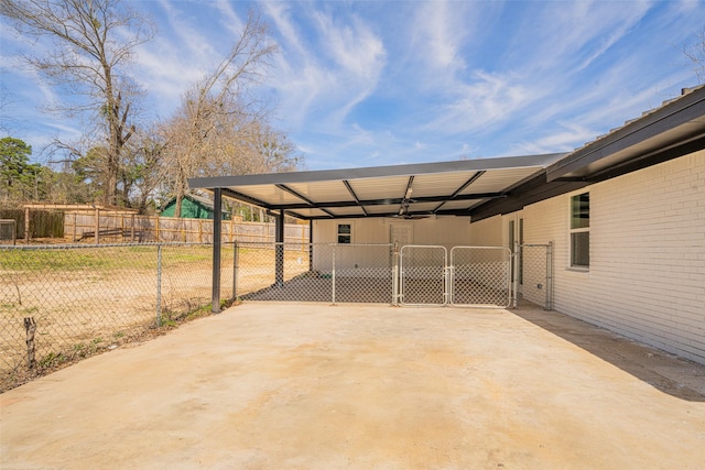 view of patio / terrace with a gate, fence, and a carport