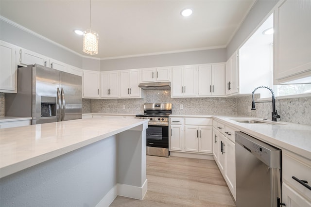 kitchen with under cabinet range hood, a sink, white cabinetry, appliances with stainless steel finishes, and backsplash