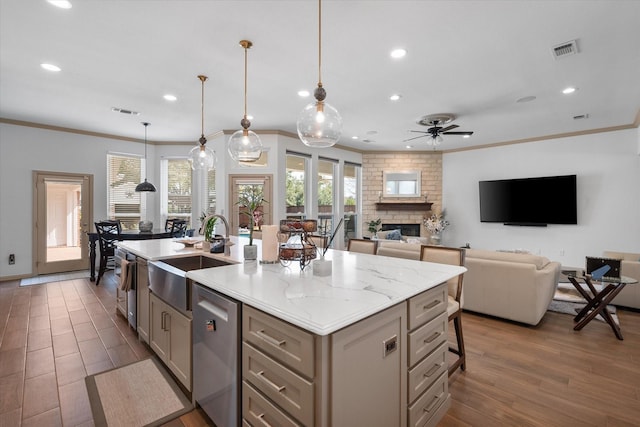 kitchen featuring a fireplace, visible vents, a sink, and gray cabinetry